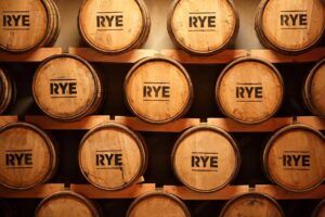 Rye whiskey maturing in a stack of oak spirit barrels labelled with the word "Rye".