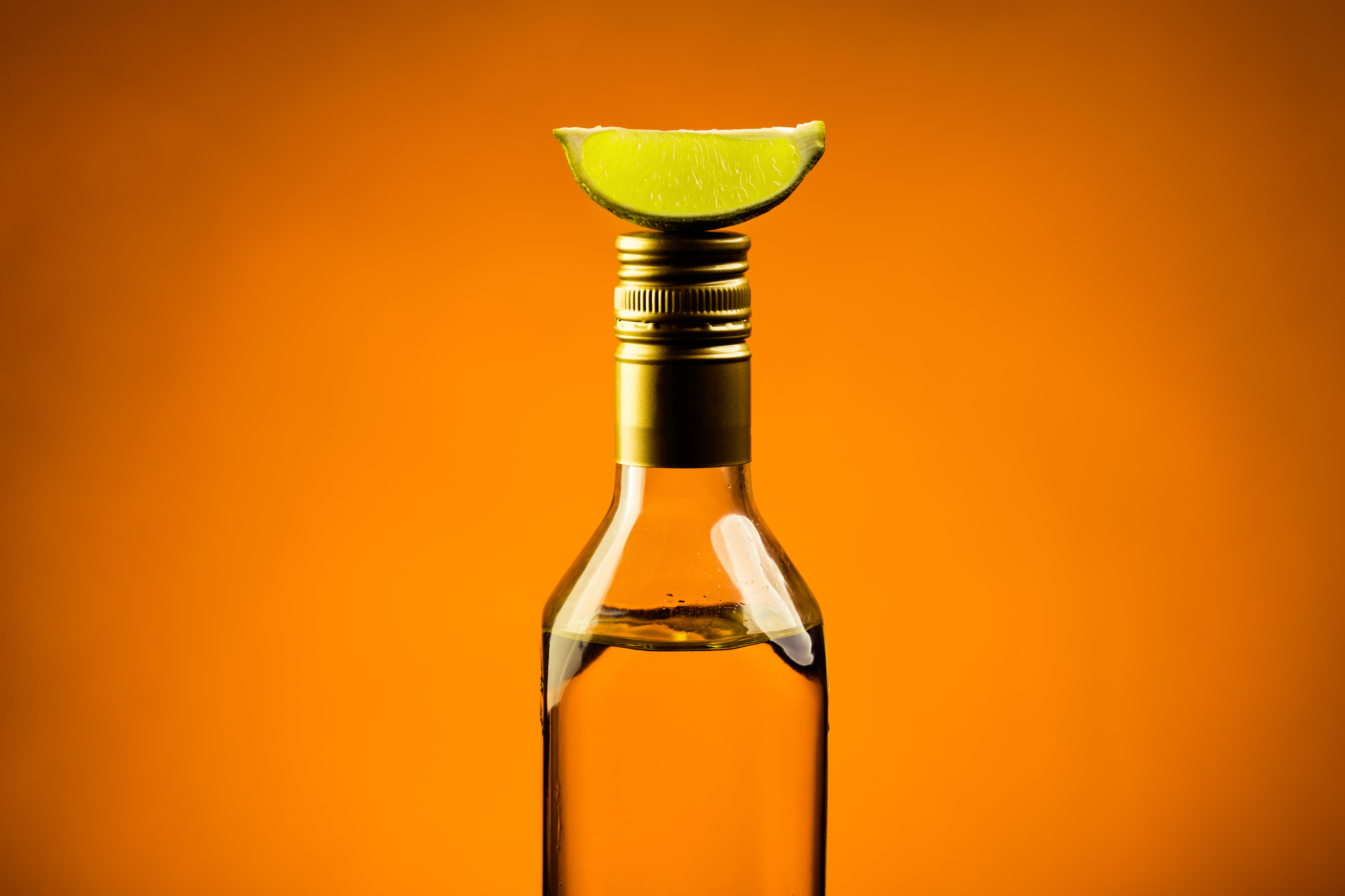 Single,Mexican,Tequila,Bottle,With,Slice,Of,Lime,On,Hot