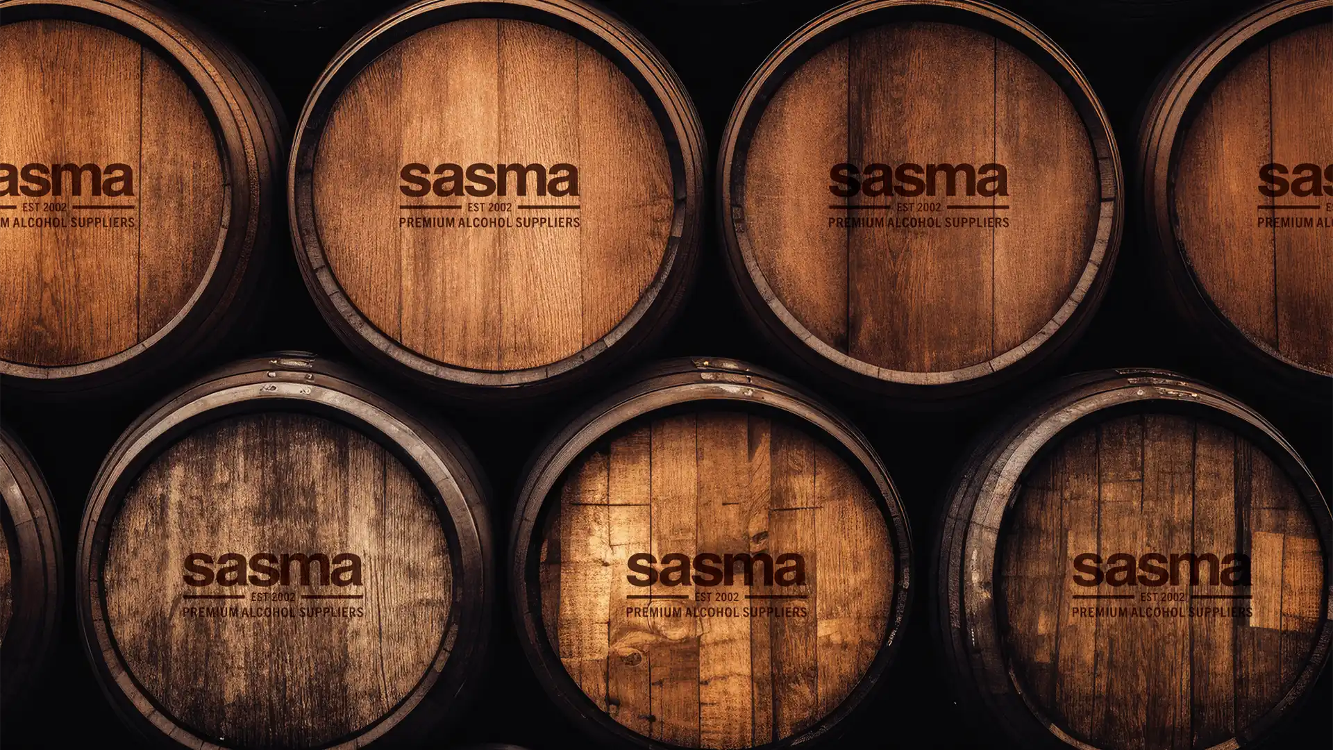 Wooden barrels stacked in rows with the "Sasma" logo and "Premium Alcohol Suppliers" text. The image conveys an authentic and rustic feel.