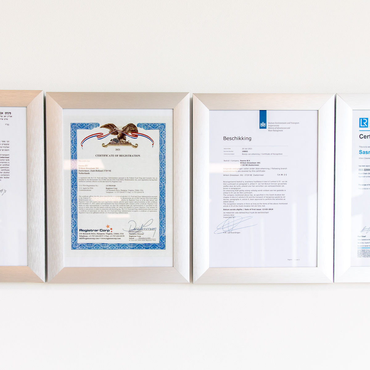 Three framed certificates hang on a wall, showcasing achievements in varied formats and languages. The image conveys professionalism and accomplishment.